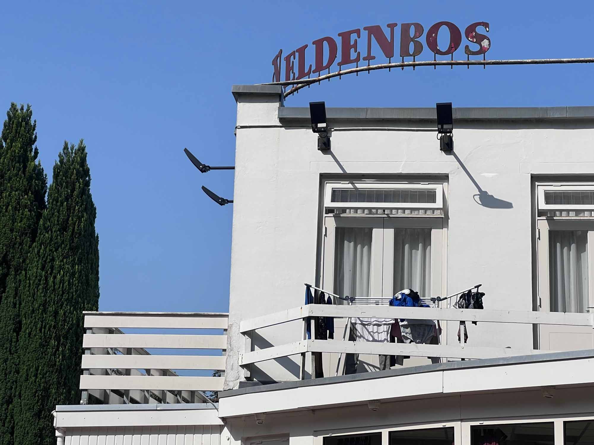 Voorkant van Hotel Veldenbos in Nunspeet met balkon en opschrift Veldenbos